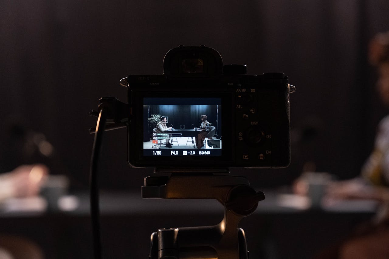 brand-03 Close-up of a camera recording a podcast interview in a studio setting.